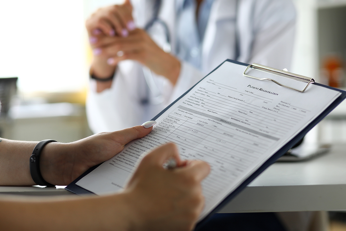 A patient filling out a form with their doctor.