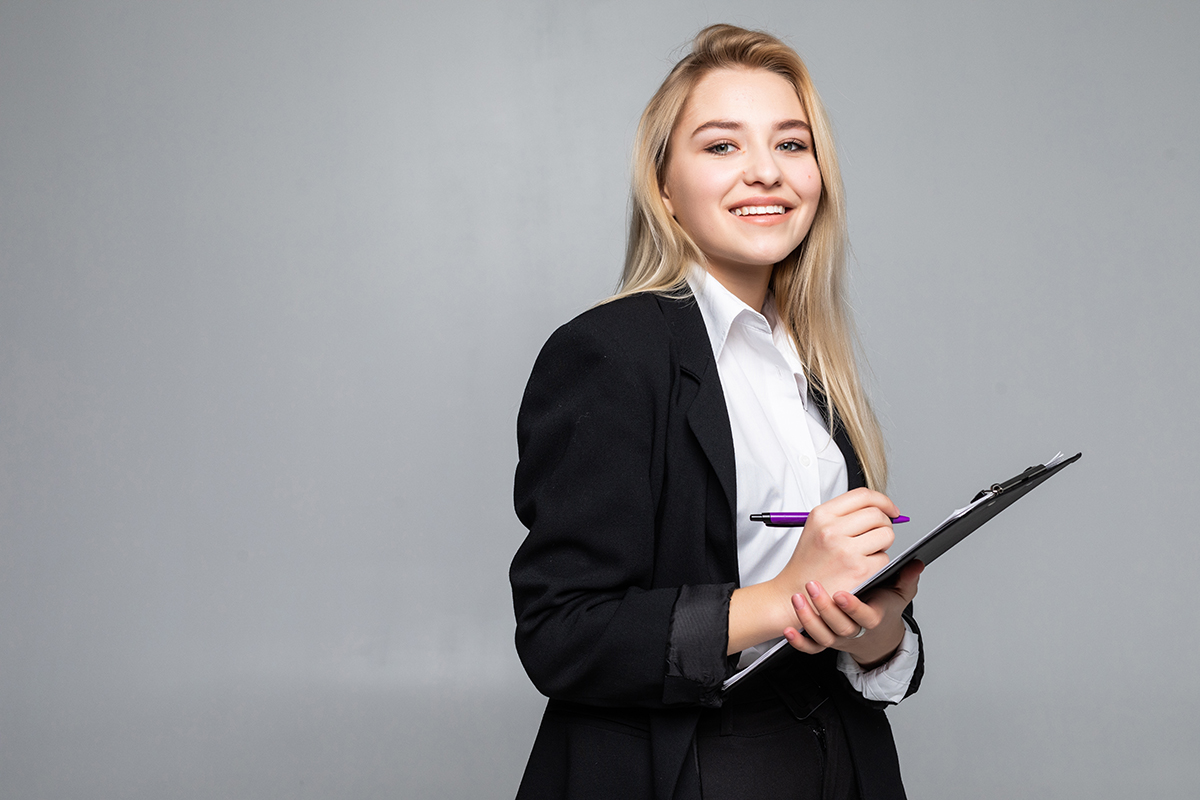 A woman holding a pen and clipboard.