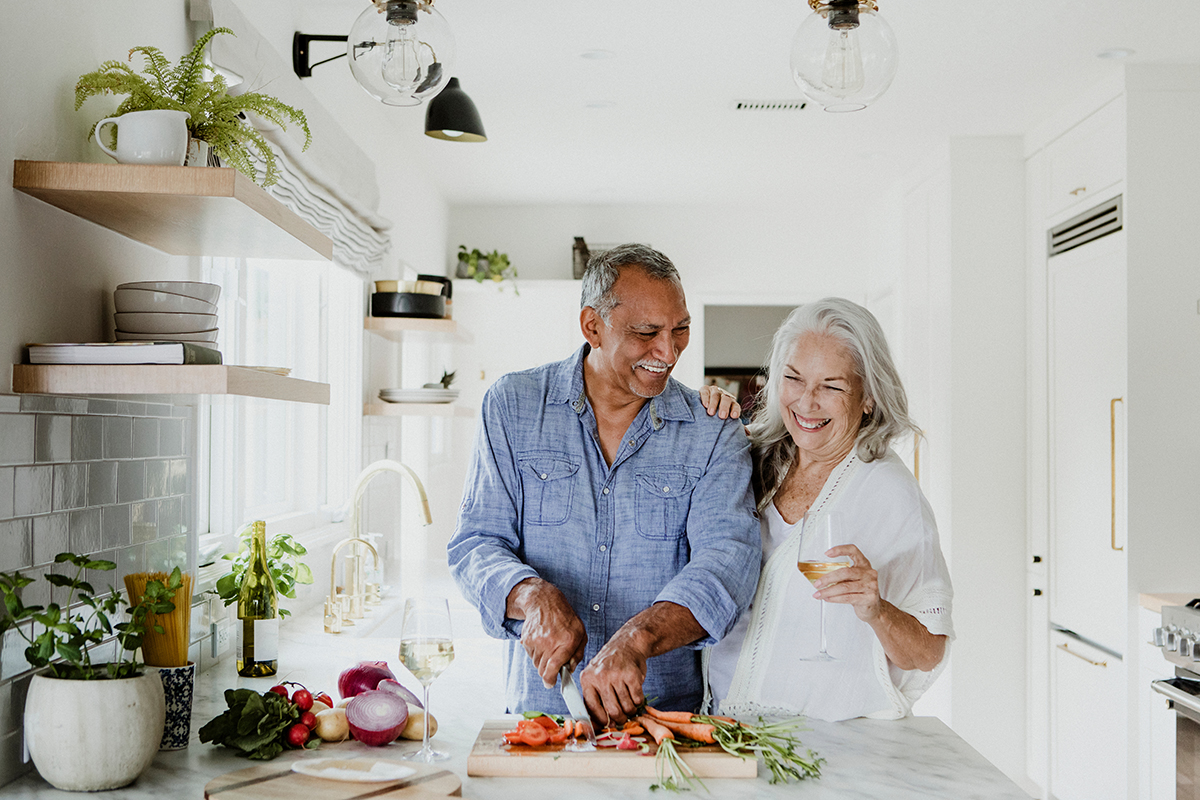 An older couple cooking together.