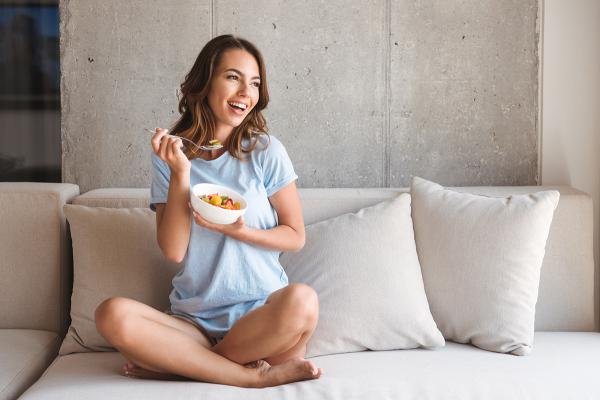 A woman eating salad.