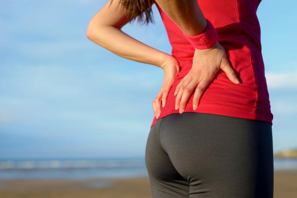 A woman holding her lower back.