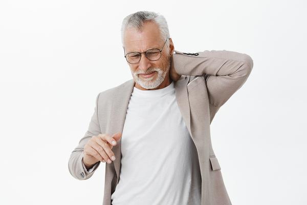 A man holding his neck in pain.