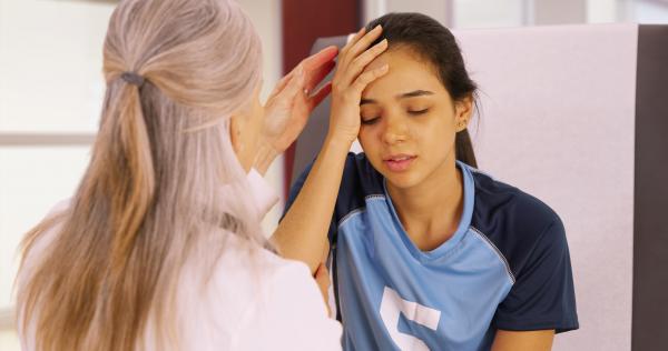 A young girl holding her head in pain.